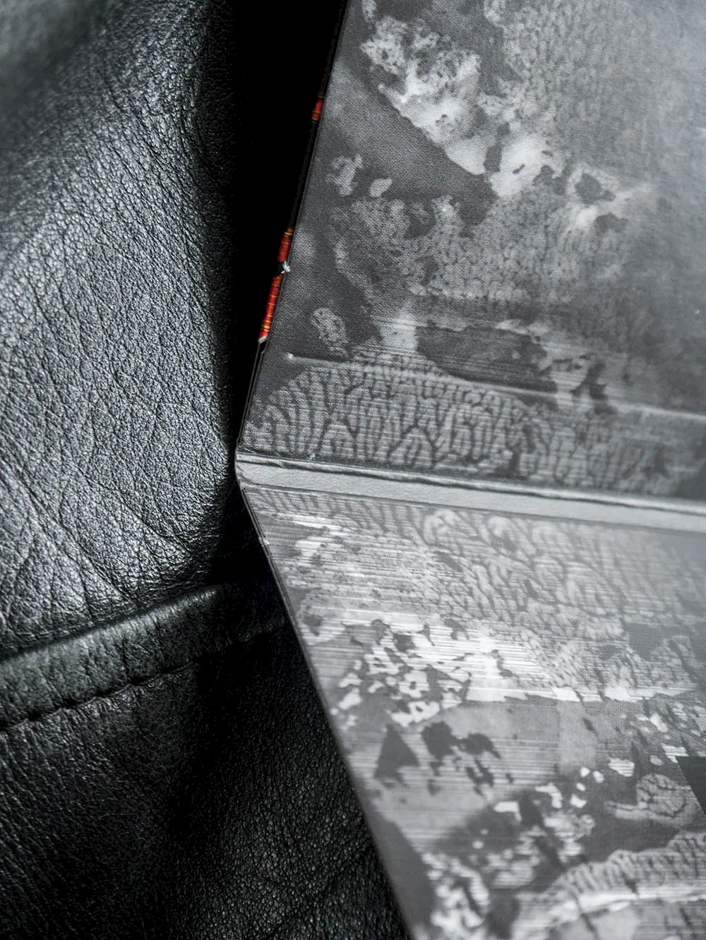 Detailaufnahme des gefalteten Booklets von «Centillion» auf schwarzem Leder