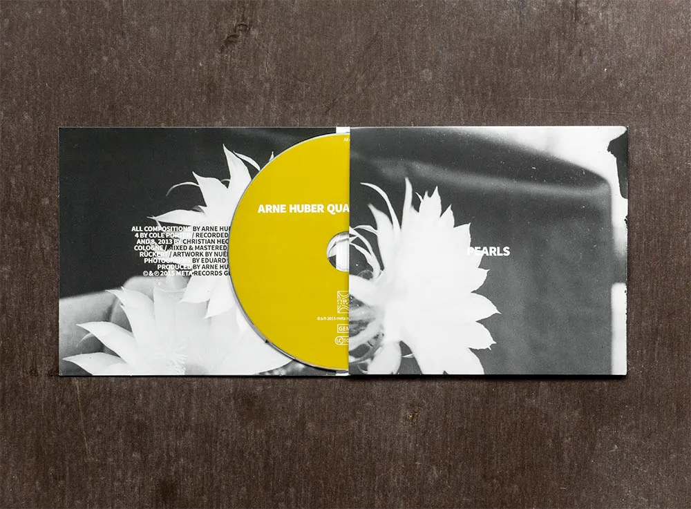 Open CD digipak with a yellow disc nestled between black-and-white photographs of flowers